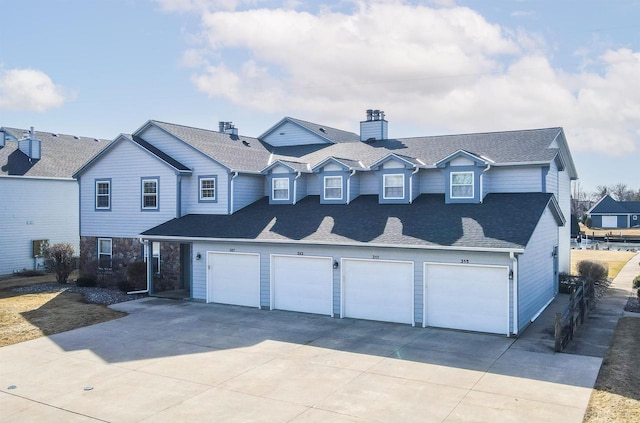 view of front of home featuring a chimney, a garage, concrete driveway, and roof with shingles