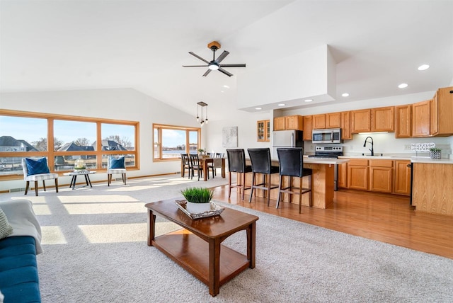 living room featuring light colored carpet, light wood-type flooring, recessed lighting, high vaulted ceiling, and a ceiling fan