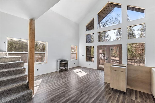 living room featuring stairs, french doors, dark wood-type flooring, and high vaulted ceiling