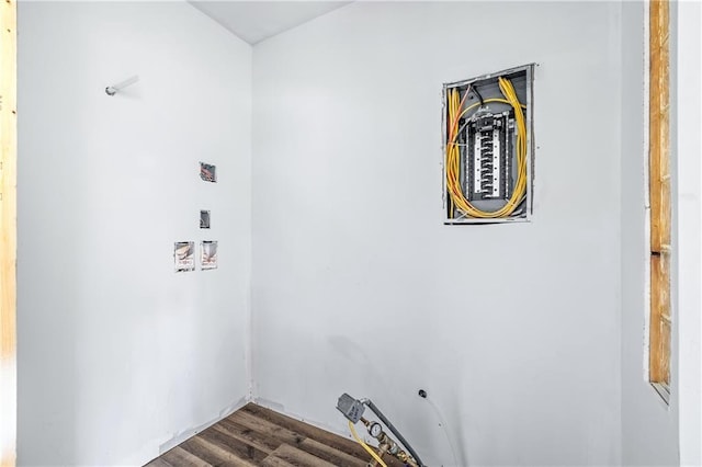 clothes washing area with dark wood finished floors