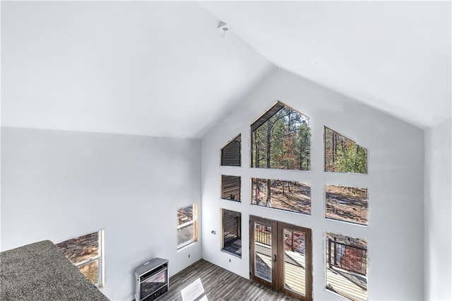 interior space with heating unit, french doors, high vaulted ceiling, and wood finished floors