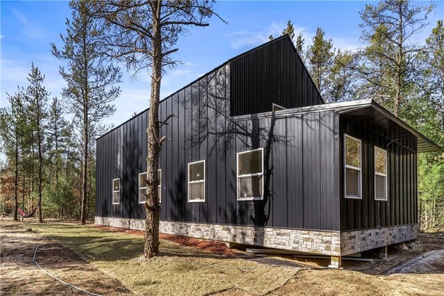 view of side of property with stone siding and board and batten siding