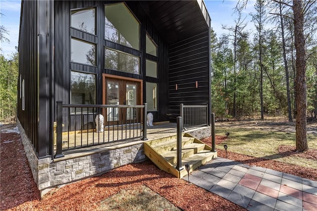 doorway to property featuring stone siding and french doors