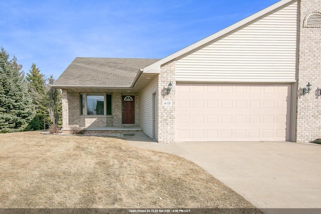 view of front of home featuring brick siding, driveway, an attached garage, and roof with shingles