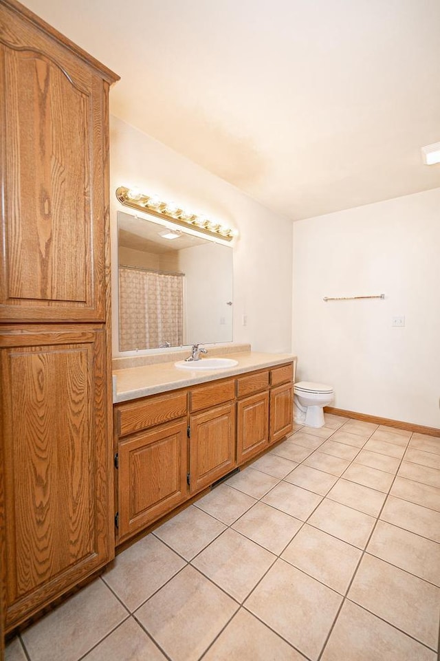 full bathroom with tile patterned flooring, toilet, vanity, and baseboards