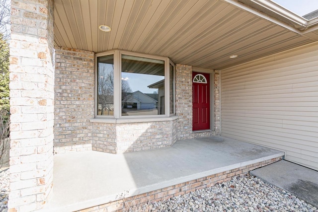 view of exterior entry featuring brick siding