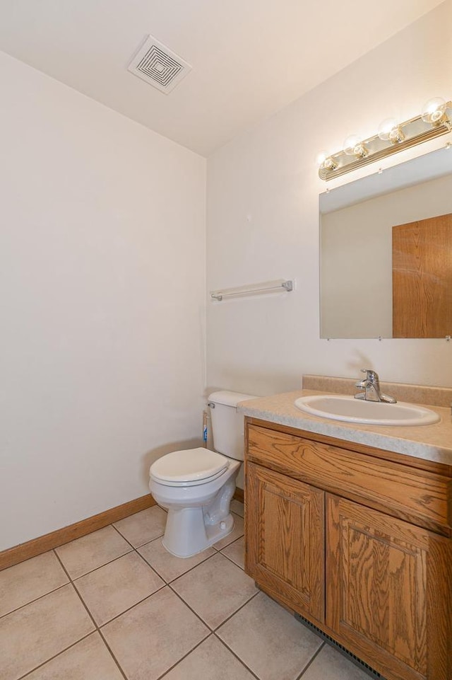 bathroom featuring vanity, baseboards, visible vents, tile patterned floors, and toilet