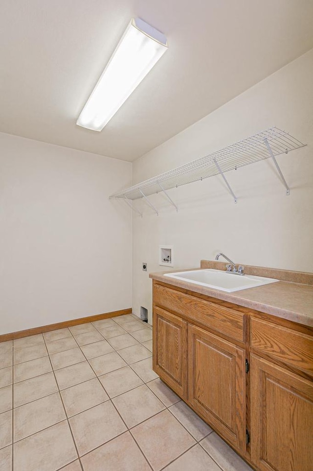 clothes washing area featuring baseboards, light tile patterned flooring, a sink, washer hookup, and electric dryer hookup