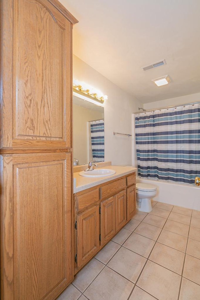 bathroom with vanity, shower / bathtub combination with curtain, visible vents, tile patterned floors, and toilet