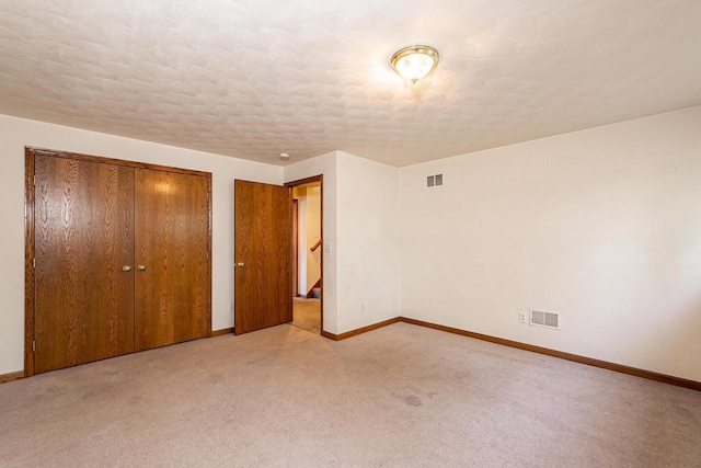 unfurnished bedroom featuring a closet, visible vents, carpet flooring, and baseboards