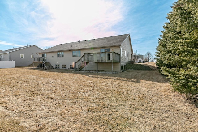 rear view of house with stairway, a wooden deck, and fence