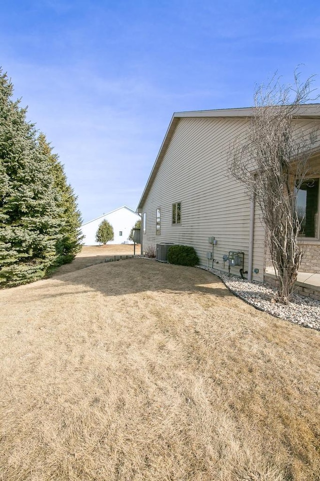 view of property exterior featuring a yard and central AC