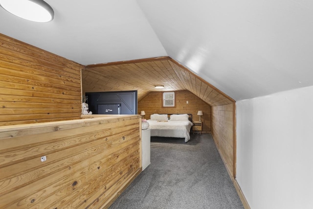 unfurnished bedroom featuring vaulted ceiling, wood walls, and carpet floors