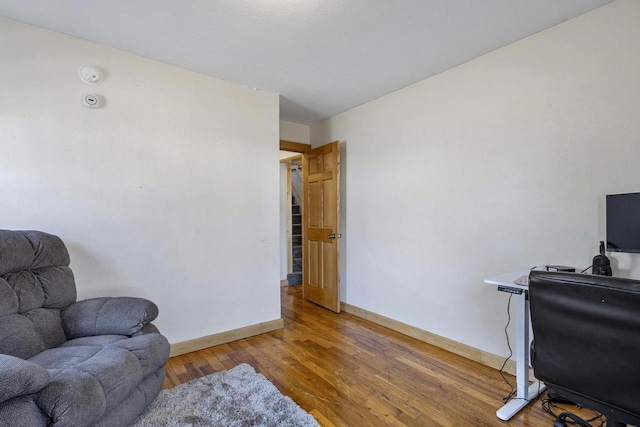 living area with baseboards and wood finished floors