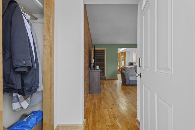 hall with light wood finished floors and baseboards