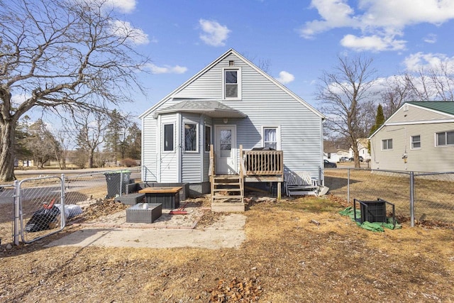 rear view of property featuring a gate and fence