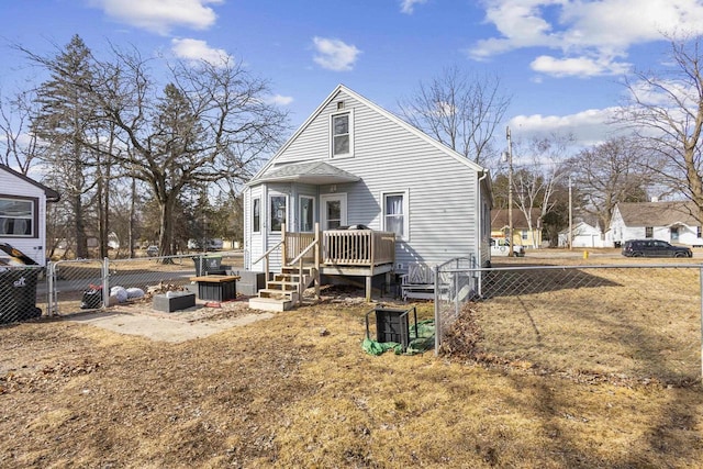 rear view of house featuring fence, a deck, and a gate