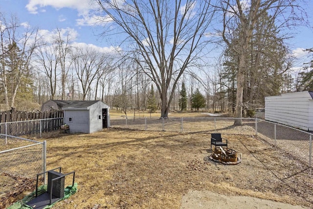 view of yard with an outdoor structure, a fenced backyard, and a shed