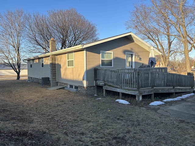 back of house with a wooden deck and a chimney