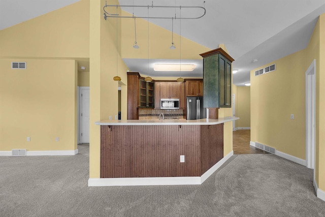 kitchen featuring visible vents, a kitchen bar, appliances with stainless steel finishes, and carpet flooring