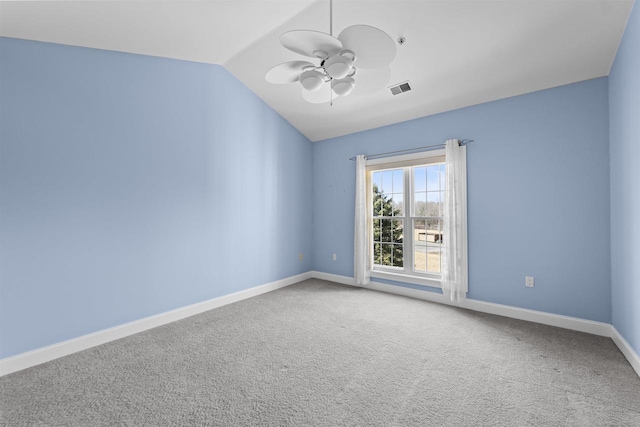 spare room with baseboards, visible vents, lofted ceiling, ceiling fan, and carpet flooring