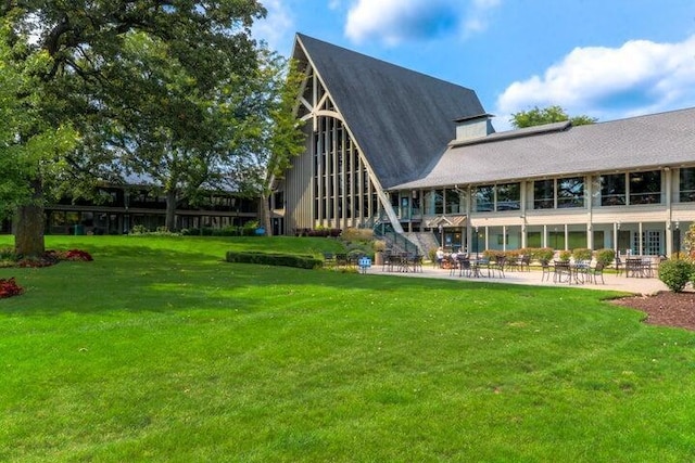 back of house with a patio and a lawn