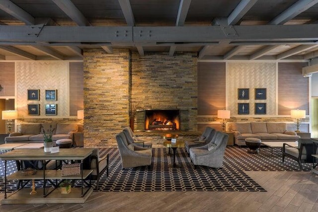 living area featuring a fireplace, beamed ceiling, and wood finished floors