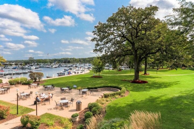 view of home's community featuring a patio, a lawn, and a water view