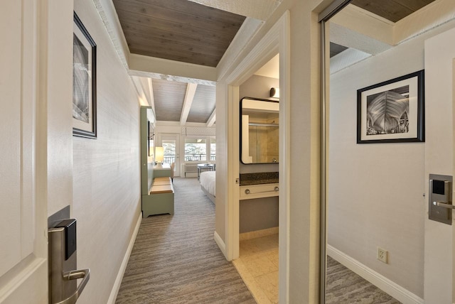 hall with beam ceiling, baseboards, and wood ceiling