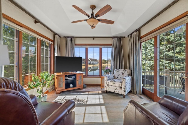 living area featuring a ceiling fan and baseboards