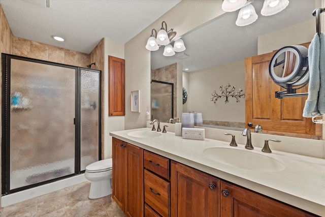 full bath with double vanity, a shower stall, toilet, and a sink