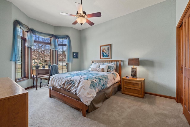 bedroom featuring ceiling fan, baseboards, a closet, and light carpet