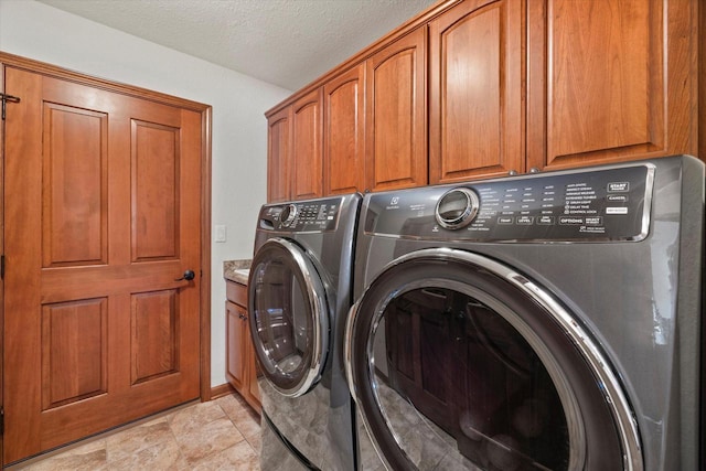 laundry room with washer and dryer, cabinet space, and a textured ceiling