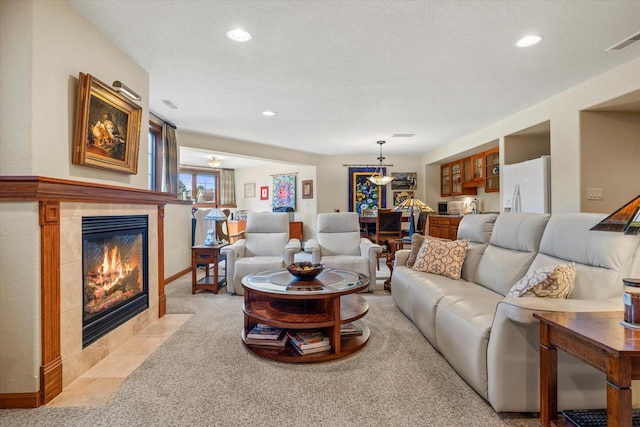 living room featuring light carpet, recessed lighting, visible vents, and a tile fireplace