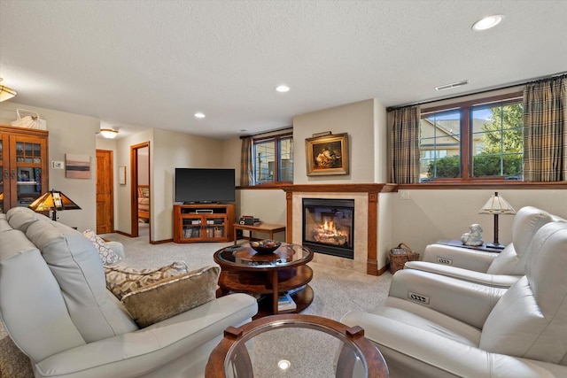 carpeted living area with recessed lighting, visible vents, a textured ceiling, and a tiled fireplace