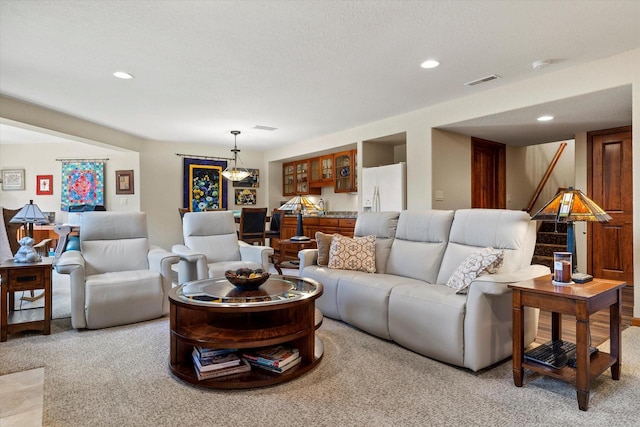 living area featuring stairway, recessed lighting, visible vents, and light carpet