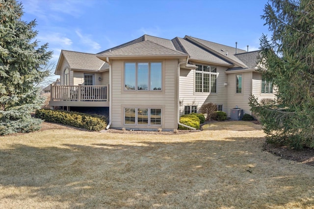 back of property with a yard, central AC unit, roof with shingles, and a wooden deck