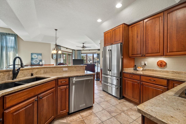 kitchen featuring brown cabinets, appliances with stainless steel finishes, ceiling fan, and a sink