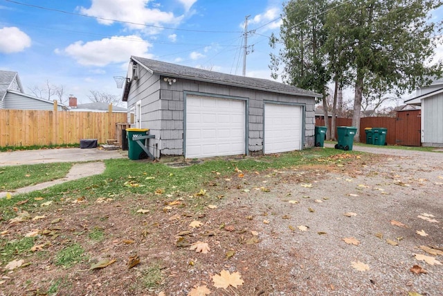 detached garage featuring fence