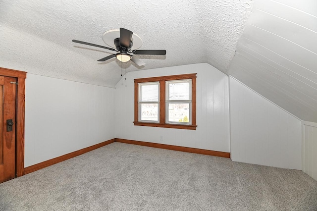 bonus room featuring a textured ceiling, lofted ceiling, ceiling fan, and carpet