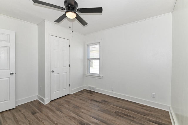 unfurnished bedroom featuring crown molding, dark wood-style floors, visible vents, and baseboards