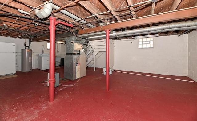 basement with washer and dryer, heating unit, water heater, freestanding refrigerator, and stairs