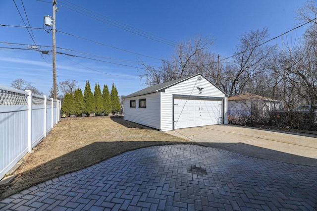 detached garage featuring fence