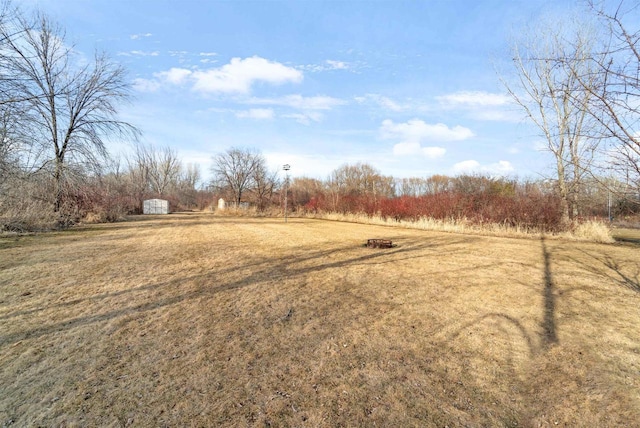 view of yard with an outbuilding, a rural view, and a storage shed