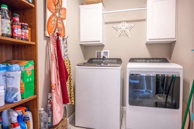 clothes washing area featuring cabinet space and washer and dryer