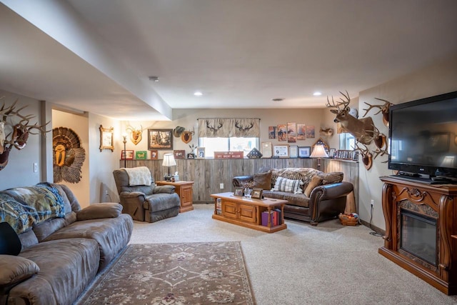 living room featuring recessed lighting, light colored carpet, and wood walls