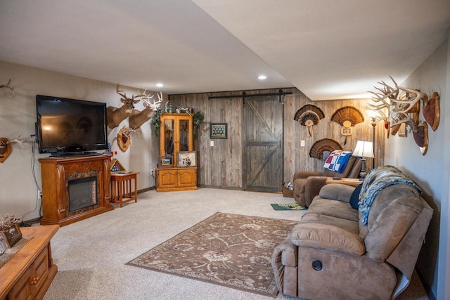 living area featuring carpet, a fireplace, recessed lighting, wood walls, and a barn door