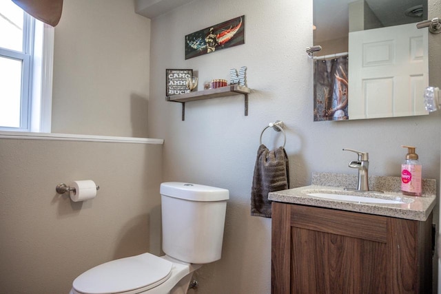 full bathroom with toilet and vanity