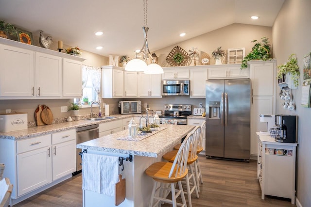 kitchen featuring a sink, stainless steel appliances, a center island, and white cabinetry