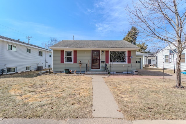 bungalow-style house featuring a garage, central AC unit, a front yard, and roof with shingles